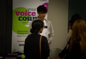 Yusuf talking to people at the Healthwatch Trafford stand