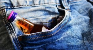 Mini bottle of alcohol in a pocket of a pair of jeans